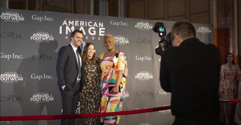 A man and two woman smiling for a red carpet photo at the American Image Awards
